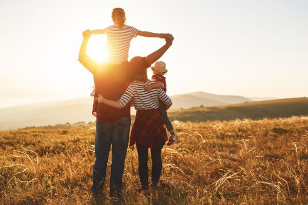 Familie schaut harmonisch in den Sonnenuntergang